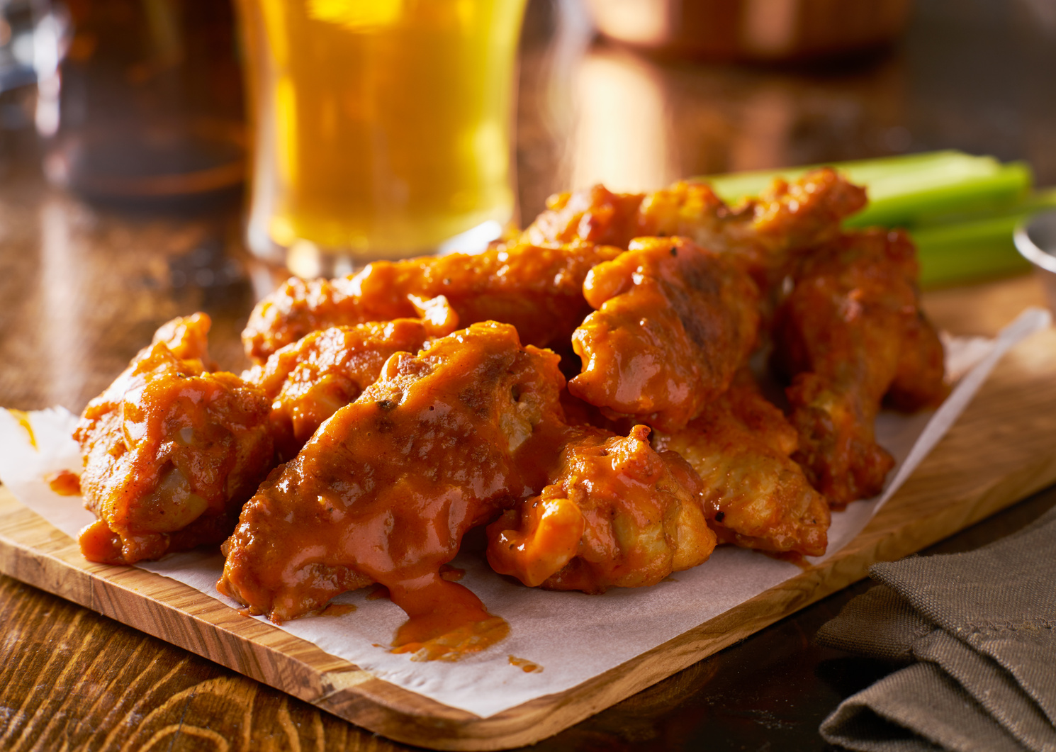 Sauced Buffalo Chicken Wings on Wooden Board with Celery